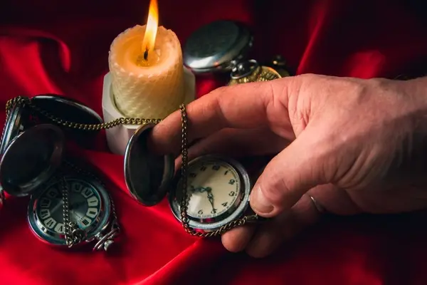 صورة تحتوي على شمعة و يد تحمل ساعة طريقة عمل سحر للزواج